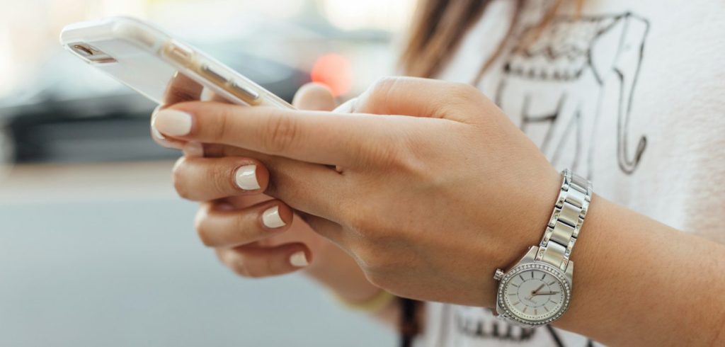 Woman holding iPhone during daytime